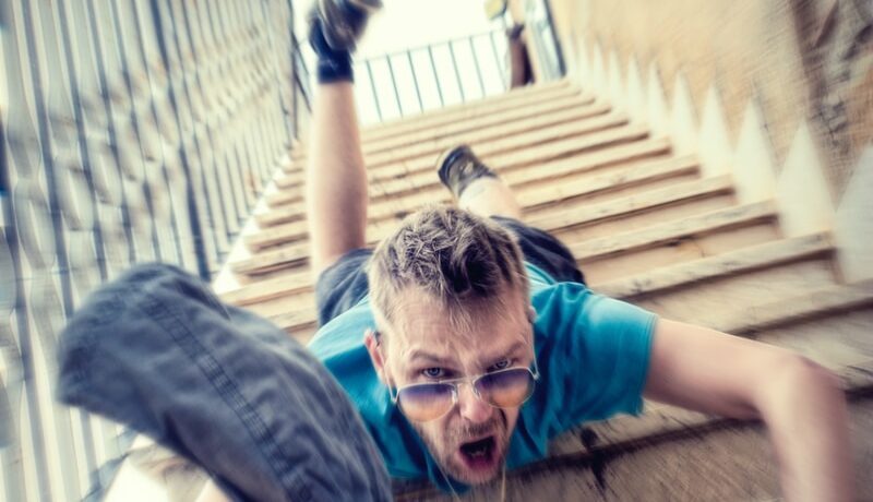 man in blue t-shirt and blue denim shorts sitting on concrete stairs during daytime