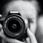 person taking photo using Canon camera in shallow focus lens