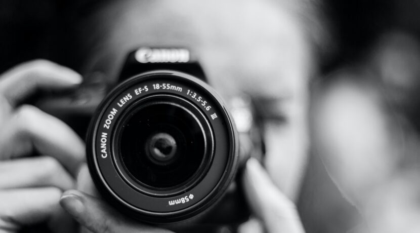 person taking photo using Canon camera in shallow focus lens