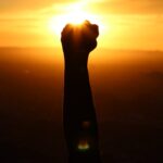 silhouette of person fist during sunset