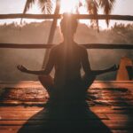 woman doing yoga meditation on brown parquet flooring