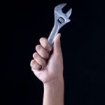 person holding gray and black metal tool