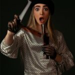 woman in white and black polka dot long sleeve shirt holding white stick