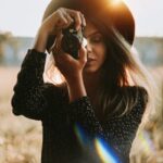 woman in black long sleeve shirt holding black dslr camera
