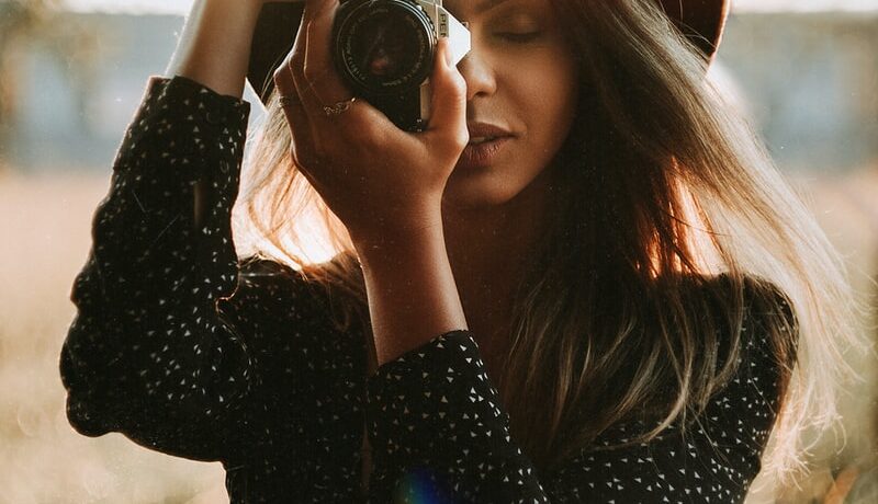 woman in black long sleeve shirt holding black dslr camera