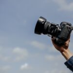 man using his black DSLR camera
