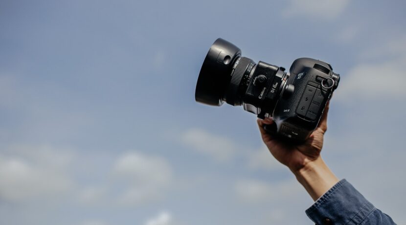 man using his black DSLR camera