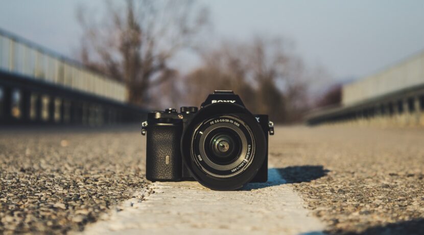 selective focus photography of black DSLR camera on gray concrete pavement during daytime