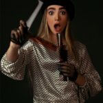 woman in white and black polka dot long sleeve shirt holding white stick