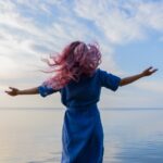 woman in blue shirt standing on water during daytime