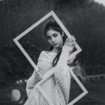 grayscale photo of girl in dress holding photo frame