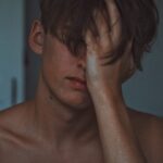 man covering face using right hand