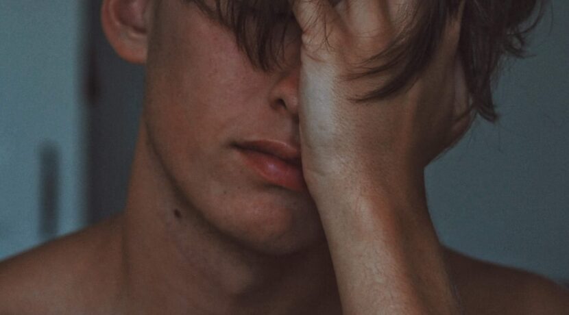 man covering face using right hand