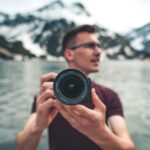 man in red crew neck t-shirt holding black camera