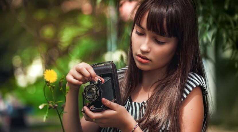 woman in black and white striped shirt holding black camera