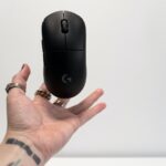 person holding black hp cordless computer mouse