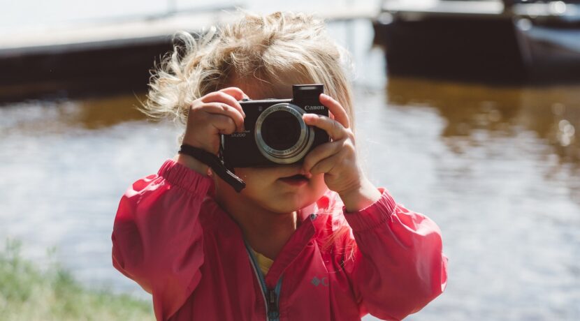 selective focus photography of girl using a camera