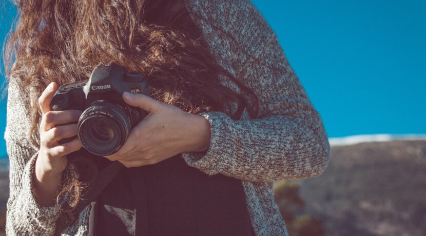 woman holding black Canon DSLR camera