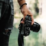 person holding black DSLR camera