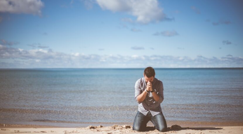 man kneeling down near shore
