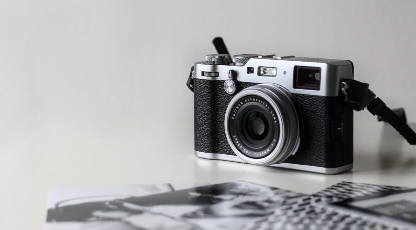 black and gray film camera near printed photos