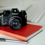 black Nikon MILC camera on red book and pen