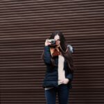woman standing holding camera taking photo