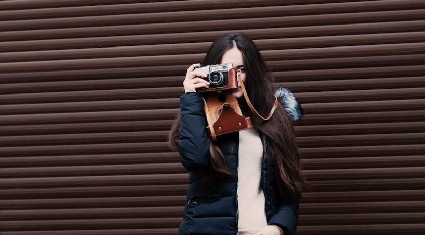 woman standing holding camera taking photo