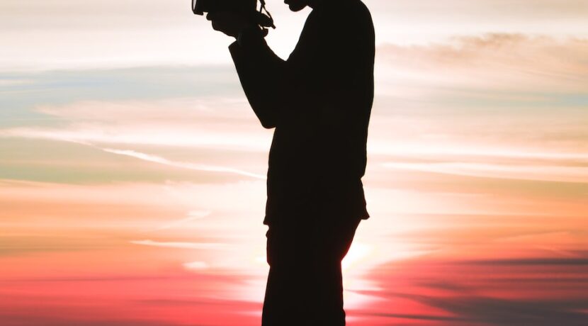 silhouette photo of man holding camera