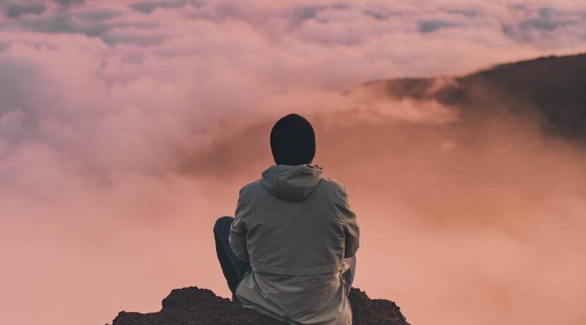 man sitting on cliff