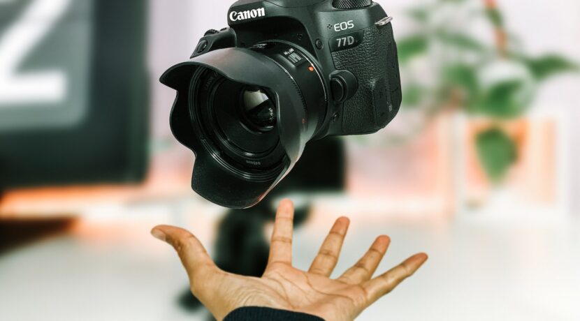 person tossing black Canon EOS 77D camera