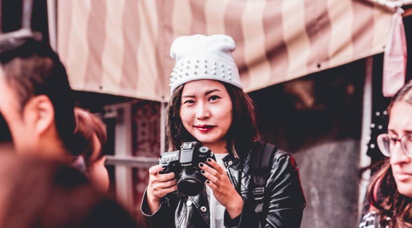 woman in black leather jacket holding DSLR camera