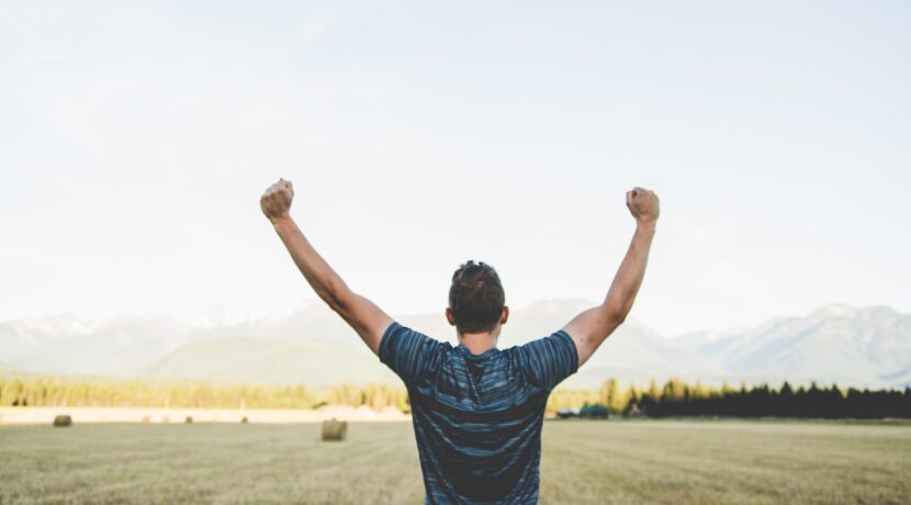 man reaching hands up high taken at daytime
