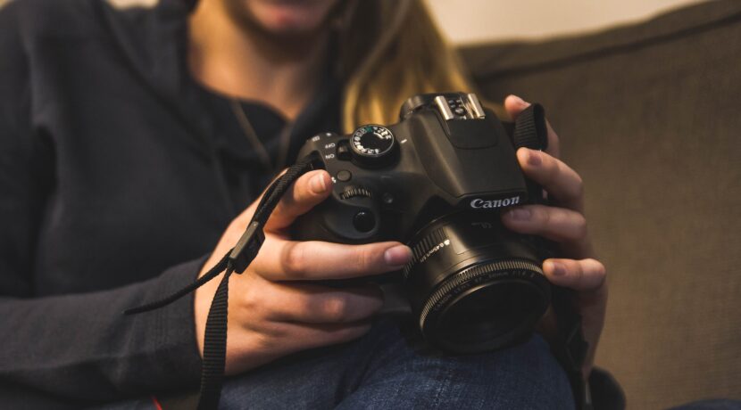 woman holding Canon bridge camera