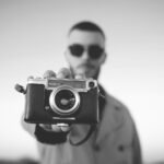 man standing and showing bridge camera