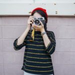 woman holding DSLR camera while taking picture
