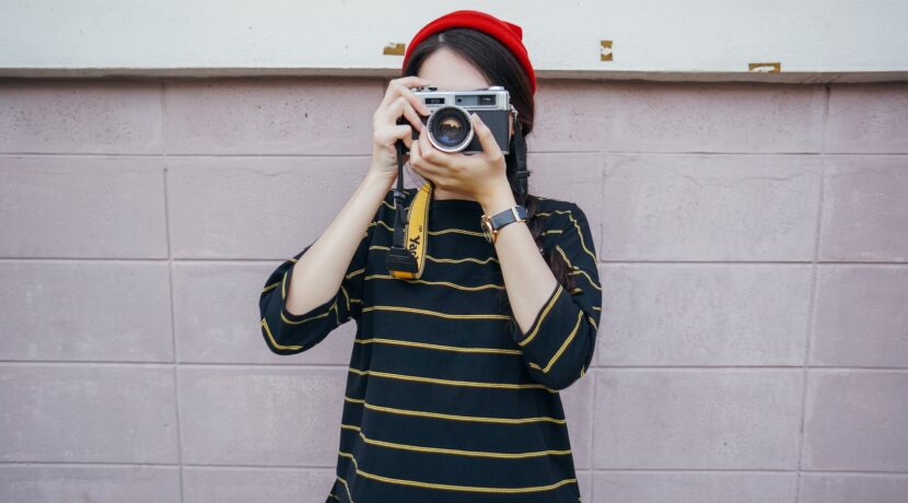 woman holding DSLR camera while taking picture