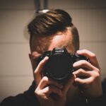 man holding Nikon DSLR camera