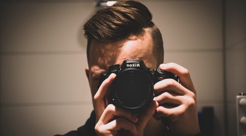 man holding Nikon DSLR camera