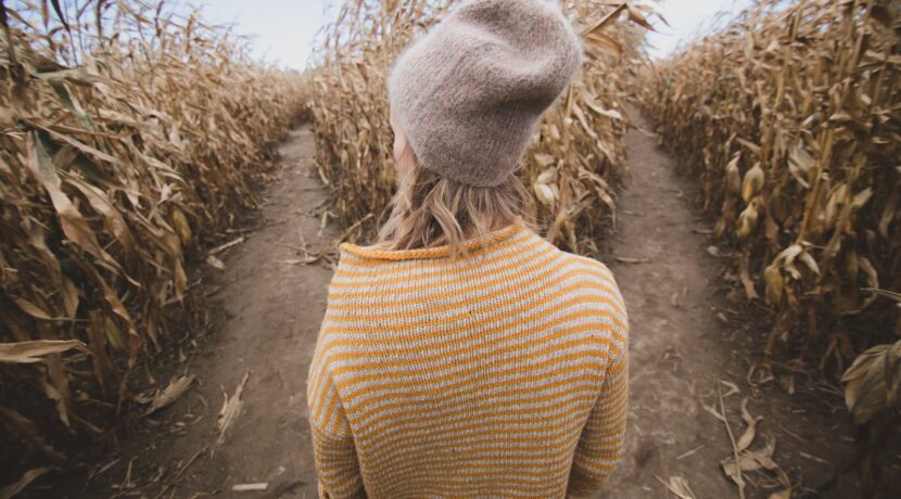 woman standing in brown field while looking sideways