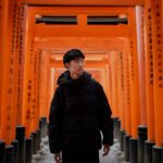 a man standing in front of a row of orange pillars