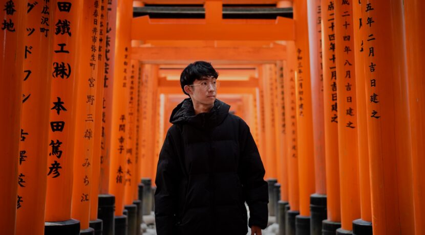 a man standing in front of a row of orange pillars