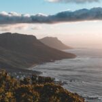 a scenic view of the ocean with mountains in the background