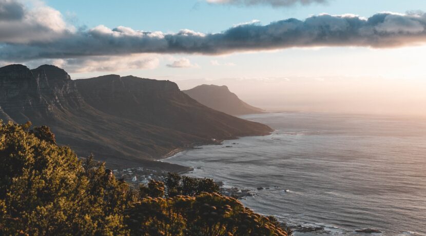 a scenic view of the ocean with mountains in the background