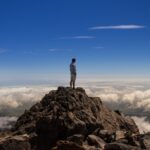 man standing on top of rock formation