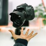 person tossing black Canon EOS 77D camera