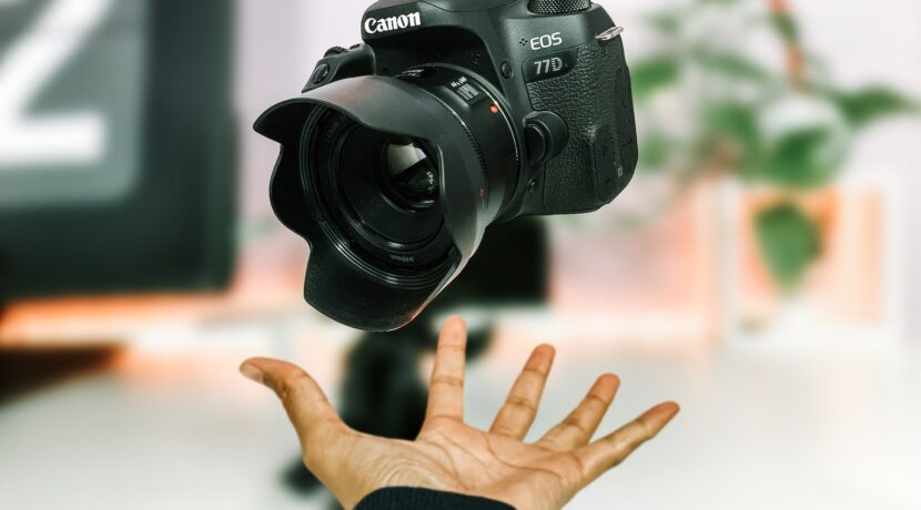 person tossing black Canon EOS 77D camera
