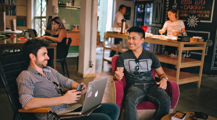two men laughing white sitting on chairs