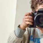 boy holding Canon DSLR camera