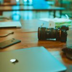 black iPhone 7 Plus and DSLR camera on table